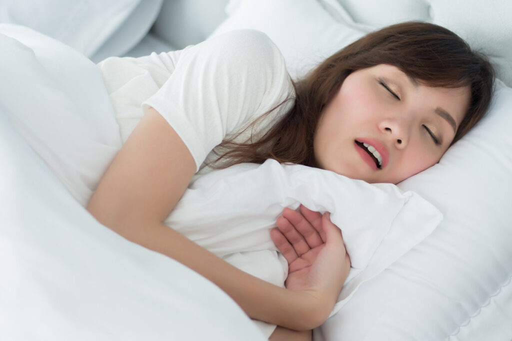 tired exhausted stressed woman snoring; portrait of stressful, exhausted woman snoring while sleeping on bed in bedroom environment; health, mental care medical concept; asian adult woman model