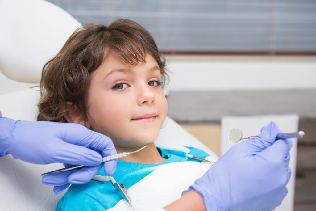 Pediatric dentist examining a little boys teeth